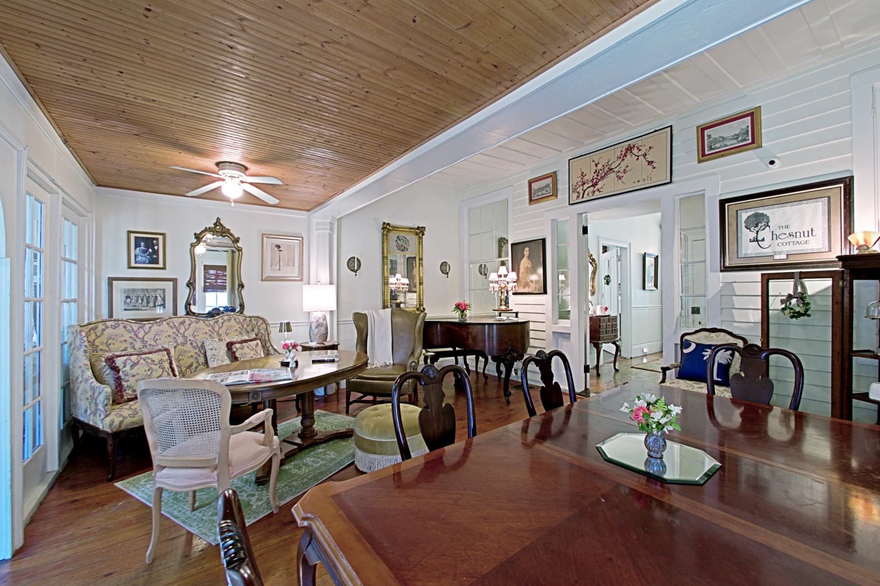 Cozy living room with antique furniture, a wooden ceiling, and decorative artwork.