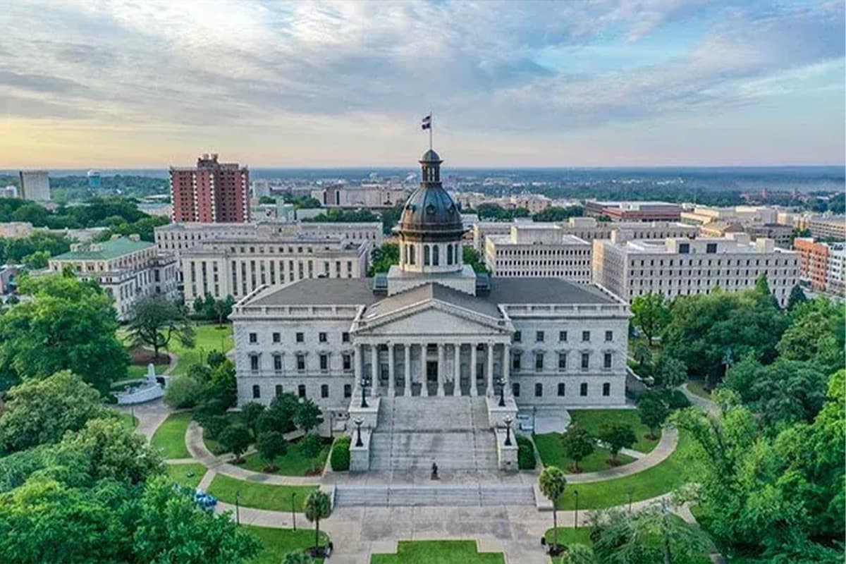 Aerial view of a historic government building surrounded by greenery and cityscape.