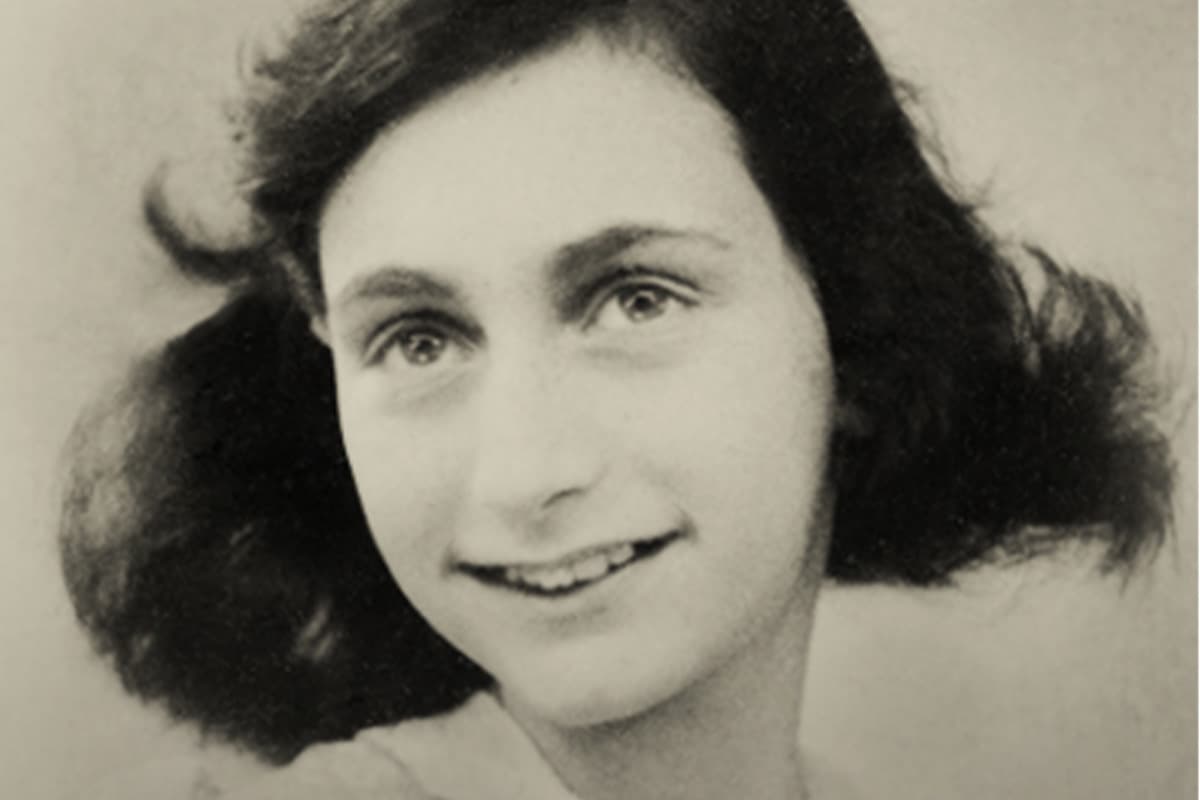 A young girl with short, wavy hair smiles warmly at the camera.