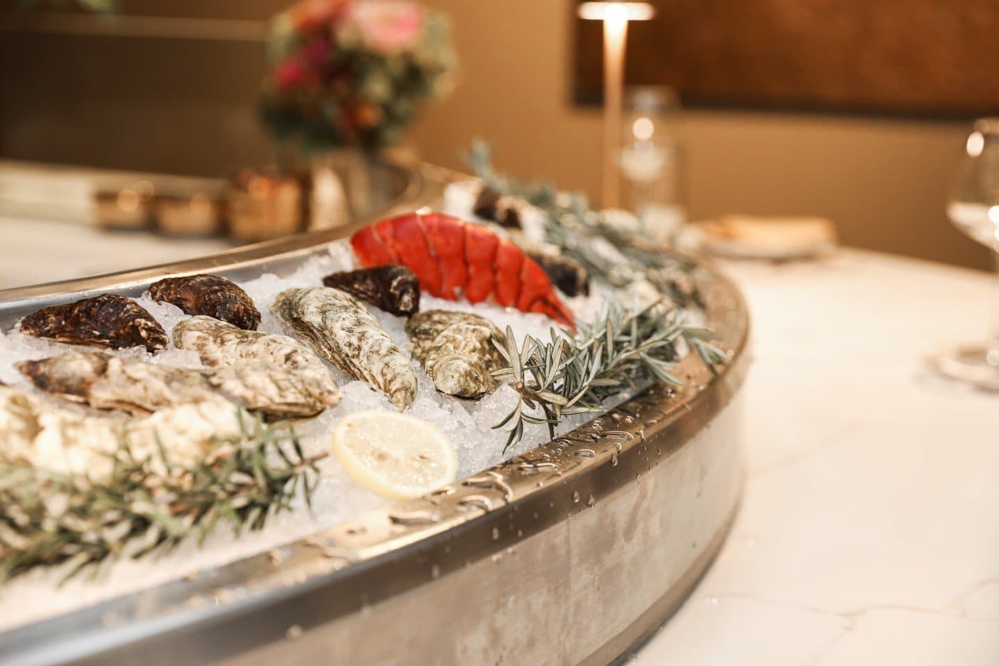 A platter of oysters and seafood arranged on crushed ice with lemon and greenery. A platter of oysters and seafood arranged on crushed ice with lemon and greenery.