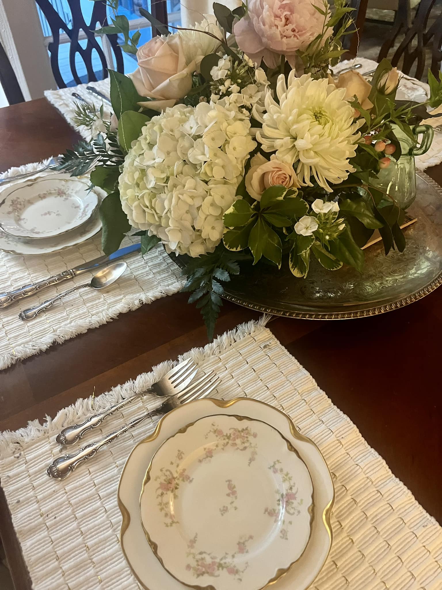 A beautifully arranged dining table featuring floral centerpieces and elegant dishware.