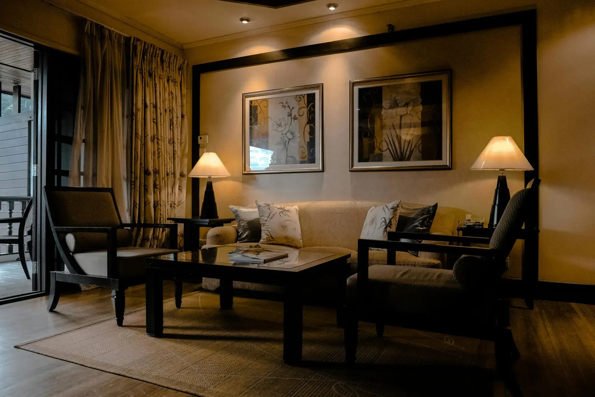 A cozy living room featuring a sofa, two armchairs, a coffee table, and soft lighting. A cozy living room featuring a sofa, two armchairs, a coffee table, and soft lighting.