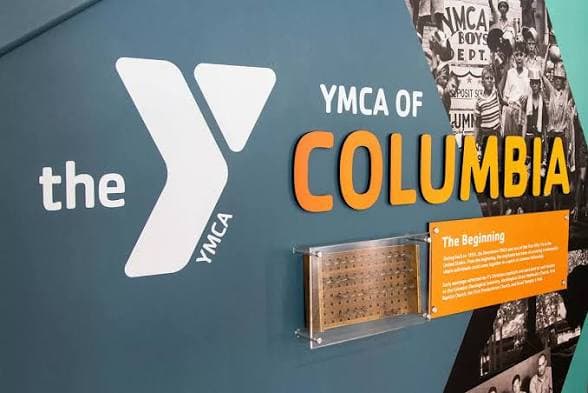 Signage for the YMCA of Columbia featuring the logo and historical information.