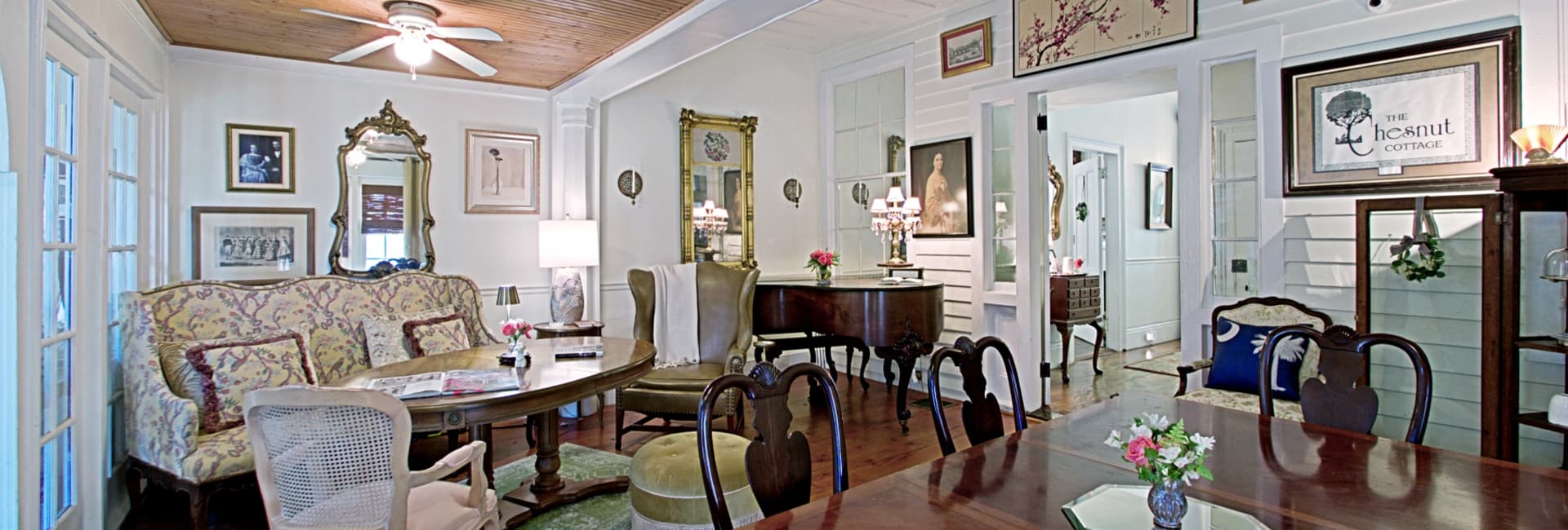 A cozy, elegantly decorated living room featuring vintage furniture, artwork, and a warm ambiance.